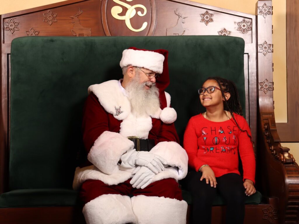 Deaf Santa with young girl in red sweater.