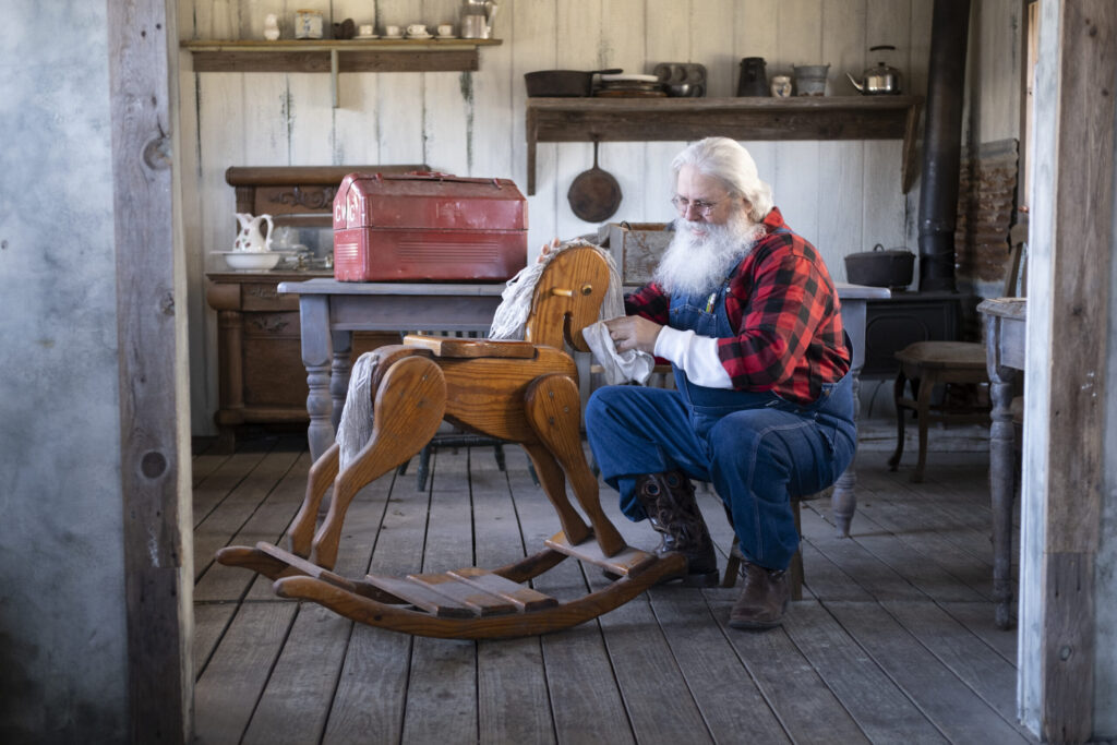 Deaf Santa working on a child’s rocking horse.