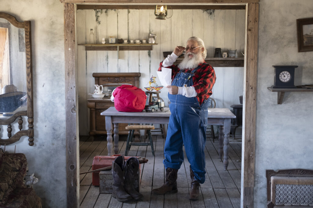 Deaf Santa organizing sack in rustic room.